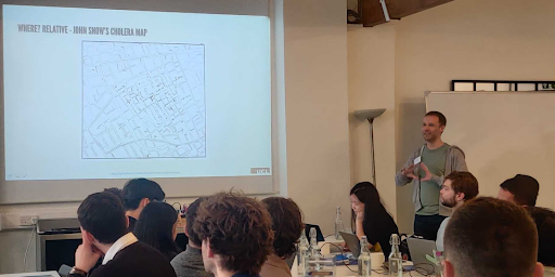 A photo of Adam Dennett (presenter) showing John Snow's famous cholera map.
